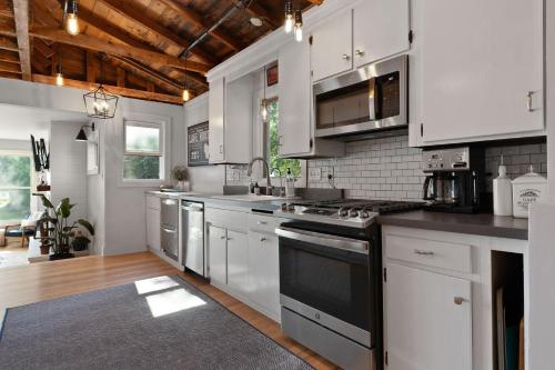 a kitchen with white cabinets and a black stove top oven at Limestone Edge by Simple Life Rentals in Baileys Harbor