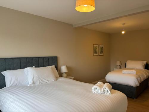 a bedroom with two beds with slippers on the bed at Creevy Cove cottage in Kildoney