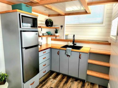 a kitchen with a refrigerator and a sink at Zion Couples Retreat Romantic Desert Tiny Home in Apple Valley