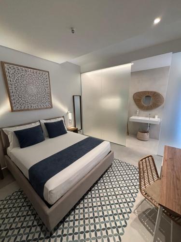 a bedroom with a large bed and a table and a chair at Borgo Bianco in Vieste