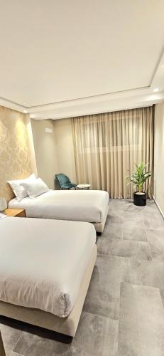 a hotel room with two beds and a couch at Andre Luxury Apart in Laayoune