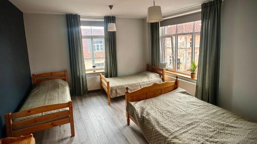 a bedroom with two beds and a window at Kuldiga Kalna Apartment in Kuldīga