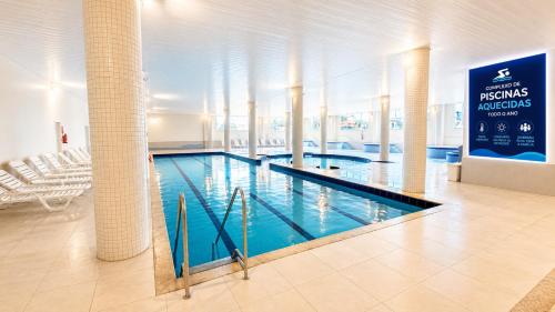 a large swimming pool in a large building at THE - Tropicanas Hotel e Eventos in Florianópolis