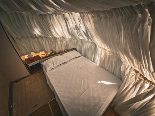 a small bed with a white canopy in a room at Under the Stars Domes in Shkodër