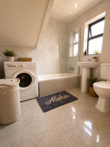 a bathroom with a washing machine and a sink at Ta Speranza Farmhouse in Victoria