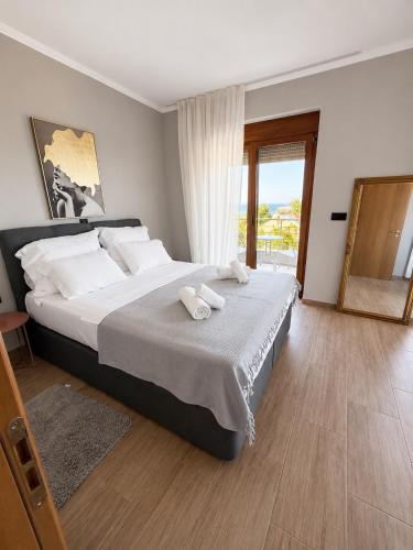 a bedroom with a large bed with white pillows at Sunny Seaside Villa-90 m from beach in Kriopigi