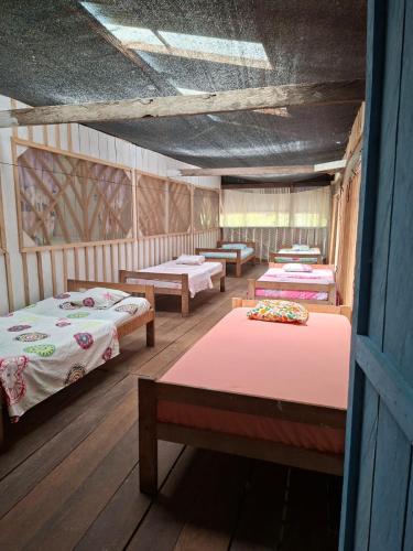 a room with four beds in a room with a ceiling at Macedonia Lodge in Macedonia