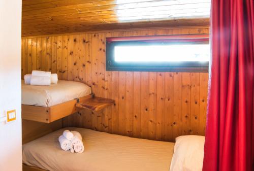 a small room with two beds and a window at Pian delle Betulle Alpine Loft in Margno