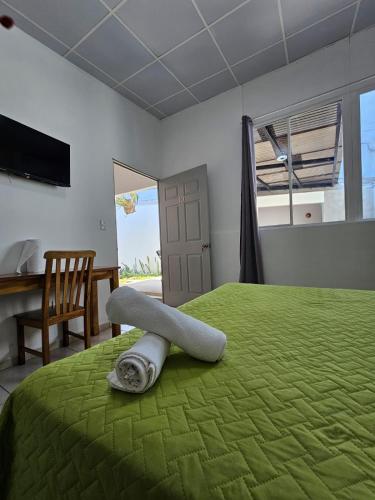 a bedroom with a green bed with a towel on it at Villa Stahl in San Salvador