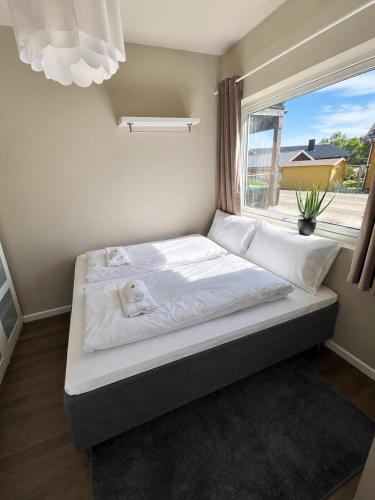 a bed in a room with a window at Nordic Comfort Suite with Hot Tub in Storeidet