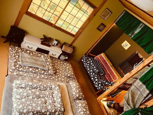 a small bedroom with a bed and a window at Mitte Lodge 健やかな大人達の田舎ホームステイ1日1組限定で駅送迎と3食家庭料理体験付き in Atami