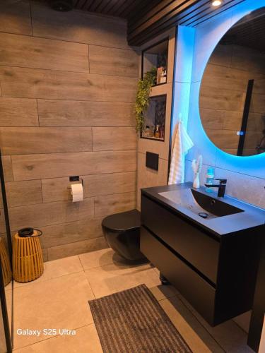 a bathroom with a black toilet and a sink at Kristiansand Mosby1 in Kristiansand