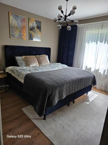 a bedroom with a bed with a blue comforter at Kristiansand Mosby1 in Kristiansand