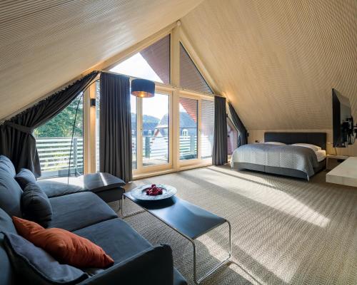 a living room with a couch and a bed at Schloss Auel Boutique Hotel & Design Golf Lodge in Lohmar