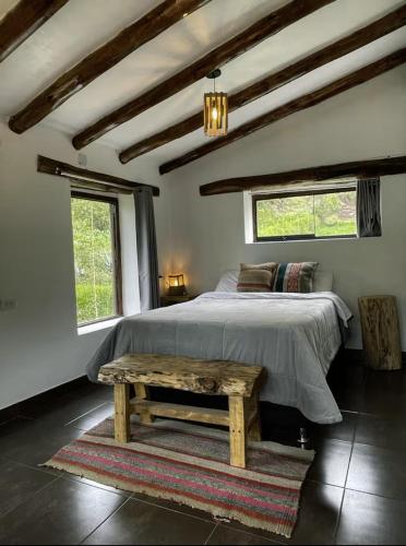 a bedroom with a bed and a wooden table at Aldealma in Pisac