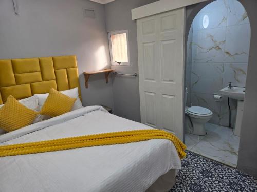 a bedroom with a bed and a bathroom with a sink at Peaceful Accommodation in Durban