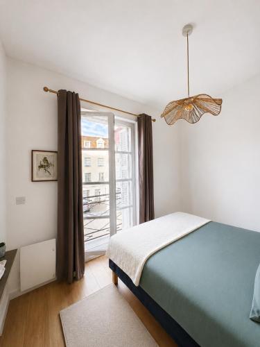 a bedroom with a bed and a large window at Le cocon de Saumur in Saumur