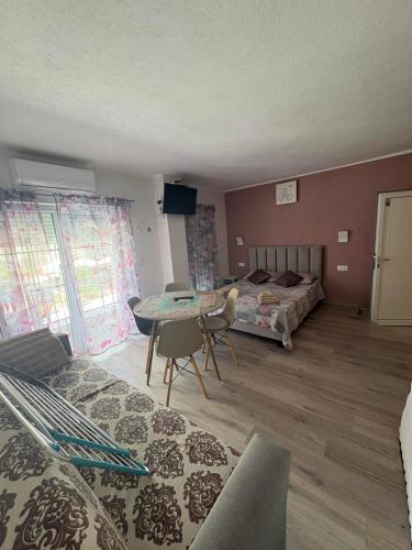 a room with two beds and a table and chairs at Perea white suites in Perea