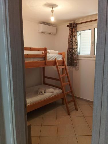 ein Zimmer mit zwei Etagenbetten und einem Fenster in der Unterkunft Amygdalos Room in Kómi
