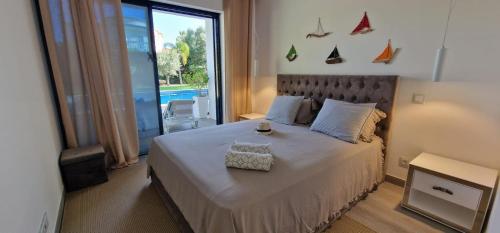 a bedroom with a large bed and a large window at Palm Suites Algarve in Portimão