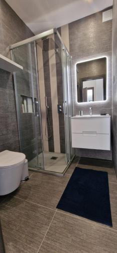 a bathroom with a shower and a toilet and a sink at Palm Suites Algarve in Portimão