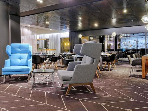 a restaurant with chairs and tables in a room at Novotel Katowice Centrum in Katowice