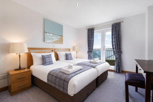 a bedroom with a bed and a desk and a window at No18 The Links Apartment, Brora in Brora