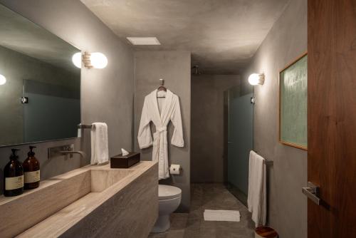 a bathroom with a white robe hanging on the wall at Casa Levora in Mexico City