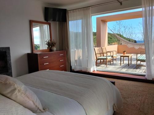 a bedroom with a bed and a view of a patio at Dona Emília in Horta