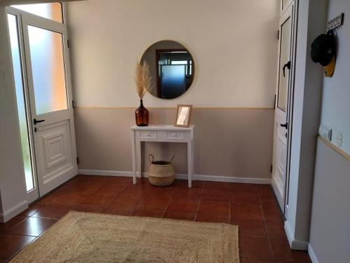 a hallway with a white table and a mirror at Dona Emília in Horta