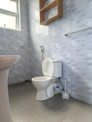 a bathroom with a toilet and a sink at Harlequin Diani in Diani Beach