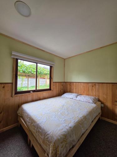 a bedroom with a large bed with a window at Hostal Celta in Pucón