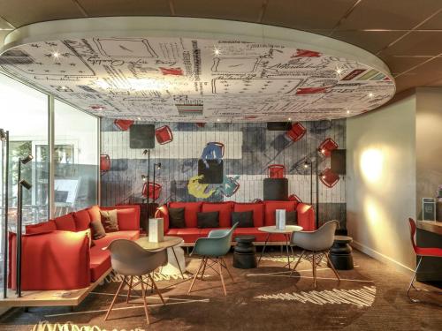 a living room with a red couch and chairs at ibis Orange Sud in Orange