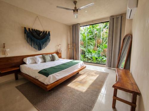 a bedroom with a bed and a large window at Yaakun in Bacalar