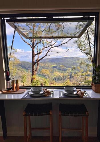 ein Tisch mit Blick auf die Berge durch ein Fenster in der Unterkunft Zenith Tiny Home in Montacute