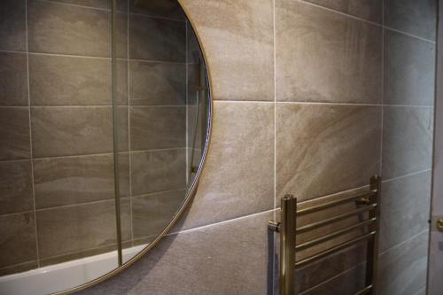 a bathroom with a round mirror on the wall at The Modern Retreat in Barnet