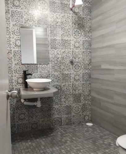 a bathroom with a sink and a mirror at Hostal Casa Pajaritos in Taxco de Alarcón