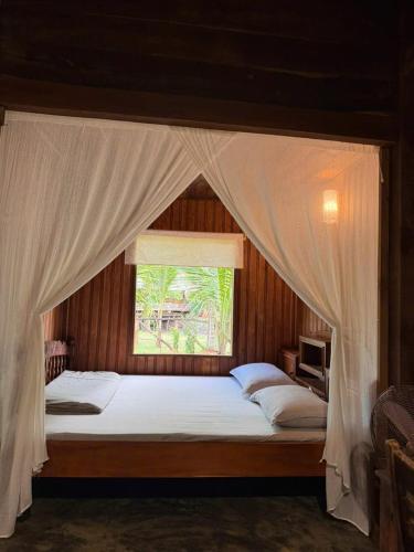 a bedroom with a large bed with a window at Xóm Sình Homestay & Farmstay Buôn Ma Thuột ĐakLak in Ðat Lý (1)