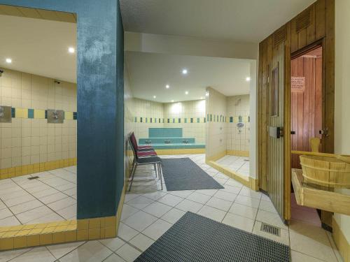 a bathroom with a sink and a chair in a room at Novotel Freiburg am Konzerthaus in Freiburg im Breisgau