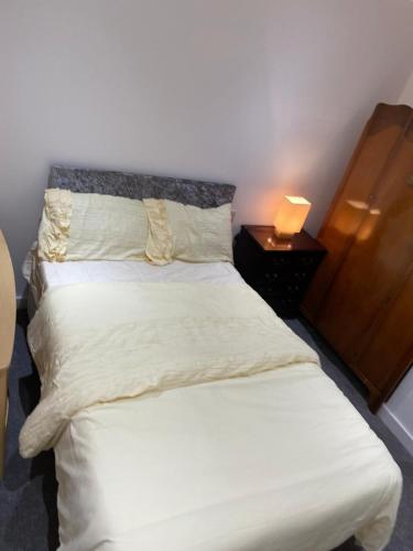 a bedroom with a white bed with a lamp on a table at Have a fun and rest in Hull
