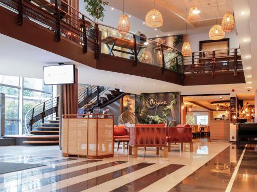 a lobby of a shopping mall with tables and chairs at Novotel Luxembourg Centre in Luxembourg