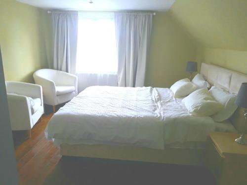 a bedroom with a white bed and a window at Charming Villa close to the sea in Errindlev