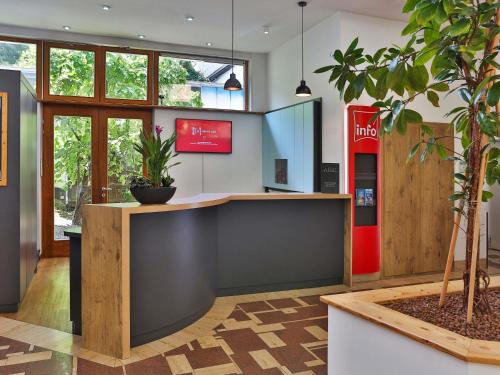 a lobby with a counter and a potted plant at ibis Berlin City Süd in Berlin