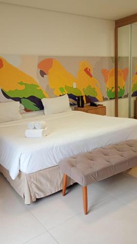 a bedroom with a large bed with a painting on the wall at Apartamento Residence Ecoresort Capivari in Campina Grande do Sul