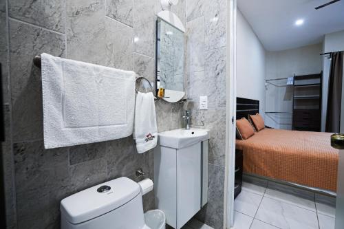 a bathroom with a toilet and a sink and a bed at Hotel y Suites Los Encantos in Sayulita