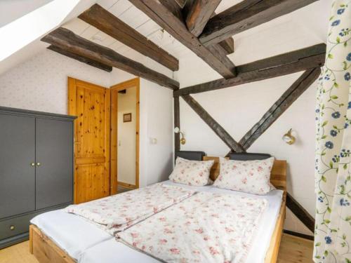 a bedroom with a large bed with wooden beams at Alma in Zierow
