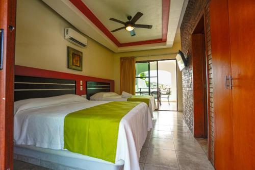 a bedroom with two beds and a ceiling fan at Hotel y Suites Los Encantos in Sayulita