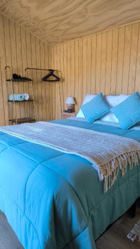a blue bed with blue pillows in a room at Elimar Ocean View in Valdivia