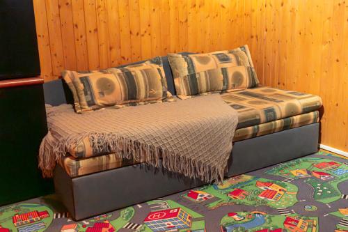 a bed in a room with a wooden wall at Chaloupka nedaleko Monínce in Sušetice