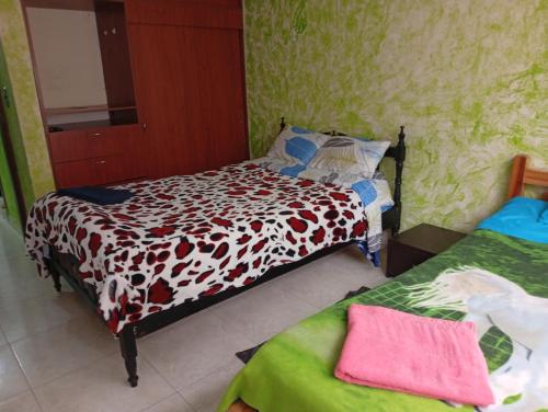 a small bedroom with a bed and two beds at hospedaje dorado engativá in Bogotá